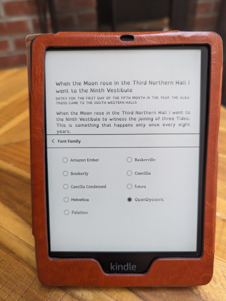 Image of a Kindle Paperwhite with the Open Dyslexic font selected. The font on the screen is weighted at the bottom. 