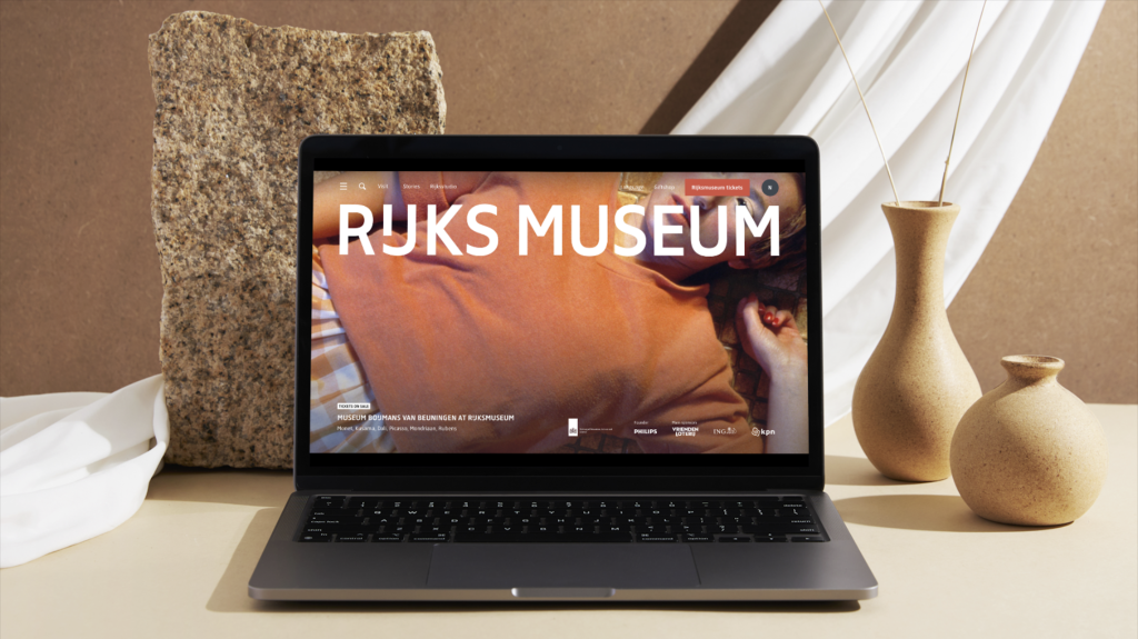 The image is a mockup of the the Rijksmuseum landing page on a laptop in desktop view.
